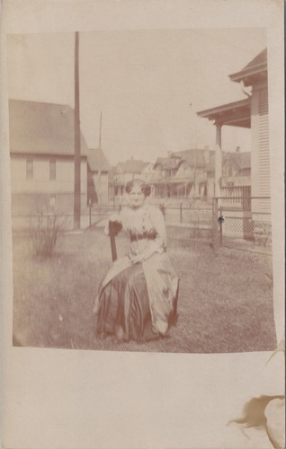 Rppc woman seated yard - seated, in